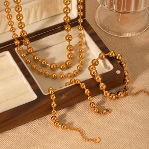 Luxuriöses Set aus goldener Edelstahl-Perlenkette und Armband auf einer Schmuckschatulle