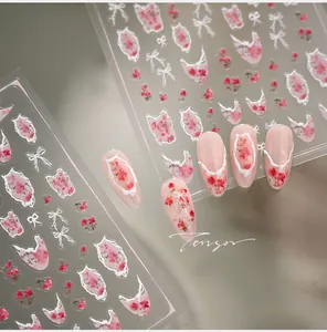 Macro detail of floral nail art stickers with pink roses and white bow designs