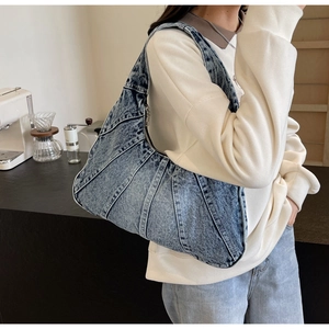 Sac bandoulière en denim bleu avec coutures incurvées dans un cadre de café élégant