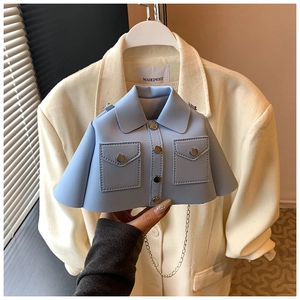 Detail of light blue blazer-shaped crossbody bag with lapels and silver chain strap