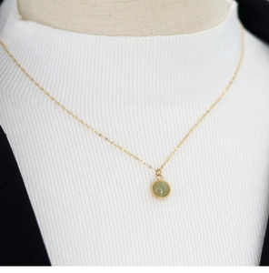 Detail of 18K gold-plated titanium chain with a translucent green agate pendant on model