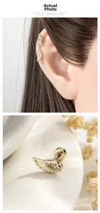 Macro detail of golden angel wing ear stud with sparkling rhinestones and screw back