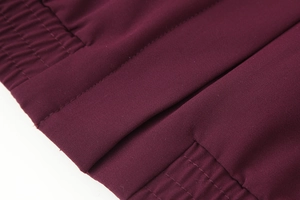 Detailed close-up of dark wine red twill fabric with precision stitching and elastic detail