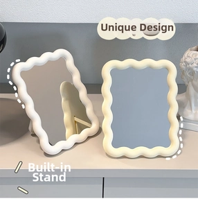 Close-up of wavy cream makeup mirror featuring a foldable stand and scalloped frame
