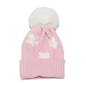 Detail of pink knit hat featuring white star patterns and a large faux fur pom-pom