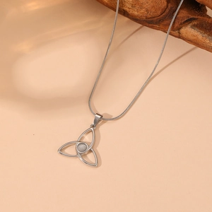 Detail of silver Celtic triquetra pendant with white opal stone and snake chain