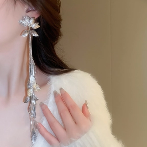 Boucles d'oreilles pendantes à pampilles argentées portées par un mannequin chic