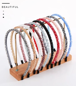 Detail showing various colors of handmade crystal beaded headbands on a display stand