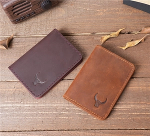 Close-up of vintage crazy horse leather card holders with fine stitching on wood surface