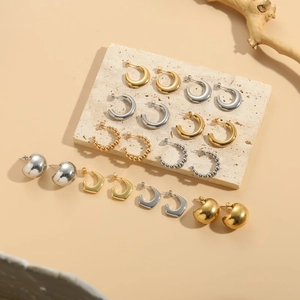 Chic 14K gold and silver geometric C-shape hoop earrings set on stone display