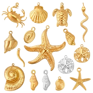 Detailed close-up of various gold and silver ocean themed stainless steel DIY pendants