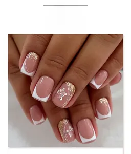 Detail of French white tip press-on nails with butterfly patterns and gold glitter