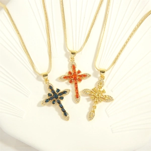 Cross necklaces with colorful zirconia and 18K gold plating on a white relief tray