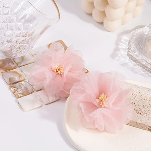 Detailed macro shot of handmade pink chiffon lace flower earrings with soft pearl accents