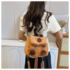 Back view of a cute brown plush capybara backpack worn by a model in a cozy interior