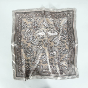 Detailed view of silver satin square scarf featuring vintage paisley patterns on white background