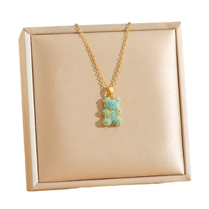 Collar de acero de titanio dorado con un colgante de osito incrustado con piedras turquesas