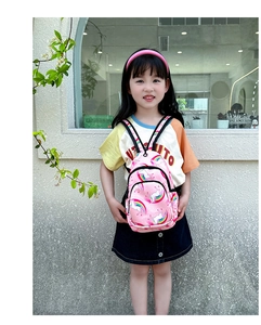 Primer plano de mochila rosa de unicornio para niñas en una modelo sobre un fondo neutral