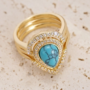 Detailed view of bohemian gold rings with teardrop turquoise stone and zircon accents
