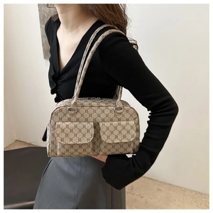 Close-up of monogram pattern underarm bag featuring dual front pockets and silver hardware