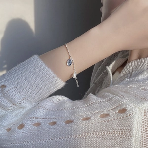Close-up of S925 silver beaded bracelet with baroque pearl and silver disc pendant