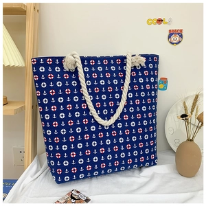 Detail of nautical print canvas tote with anchor patterns and thick rope handles