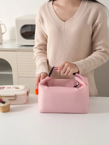 Detail of pink insulated lunch bag with buckle handle shown in a modern kitchen setting
