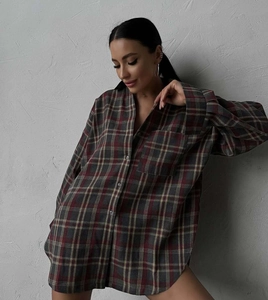 Detail of red plaid pattern and cotton fabric texture on a long sleeve casual shirt