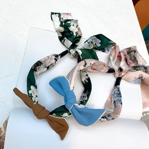 Detail of fabric headbands with floral patterns and silk bow ties in a retro style