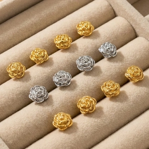 French vintage rose stud earrings in gold and silver finish on a beige velvet jewelry box