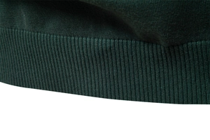 Vue détaillée du bord-côte en maille vert foncé au poignet d'un pull ajusté pour hommes