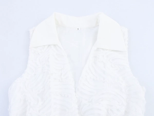 Detail showing white sleeveless shirt with lapel collar and unique wavy textured fabric