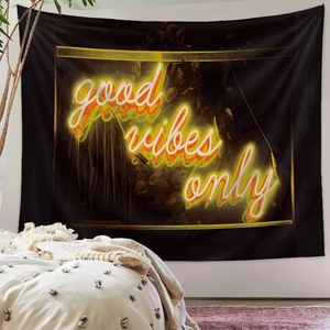 Detail of black fabric tapestry with yellow neon Good Vibes Only text for wall decor
