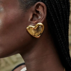 Minimalist 18k gold heart stud earrings in stainless steel on a female model