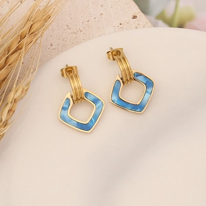 Modern geometric hollow rhombus earrings in gold and blue finish on a display tray