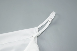 Detail of adjustable shoulder straps with silver metal rings on a white camisole dress