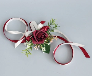 Détail de boutonnière de mariage avec rose en soie bordeaux et ses rubans élégants