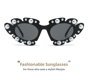Detail of black cat-eye sunglasses featuring white pearl embellishments on the frame