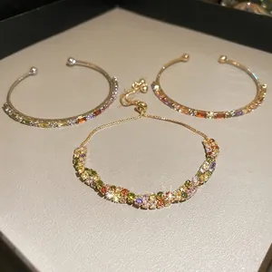 Three-piece gold-plated jewelry set with colorful baguette crystals and rainbow stones