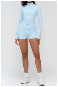 Detail of light blue zip-up yoga top and high-waist shorts set in high-elasticity fabric