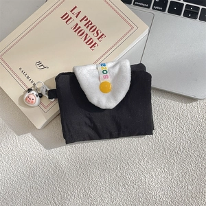Detail of cute black mini wallet with white faux fur flap, yellow button and panda charm