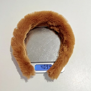 Detail showing the brown plush headband weighing 40.9g on a digital scale for accuracy
