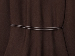 Close-up of dark brown knit fabric texture with decorative slim double waist cords