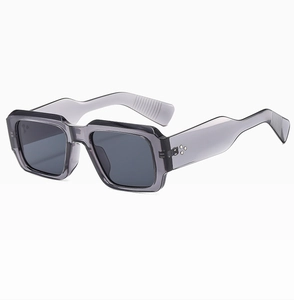 Detail of grey translucent rectangular sunglasses featuring wide temples and rivet accents