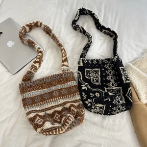Detailed view of plush lamb wool shoulder bags in brown tribal and black paisley patterns