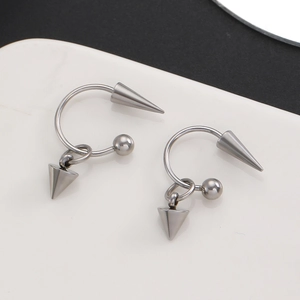 Détail de boucles d'oreilles punk en acier inoxydable en forme de C avec clous et cônes