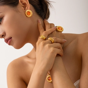 Detail of 18k gold vintage jewelry set featuring orange cat eye stone inlays and ring texture