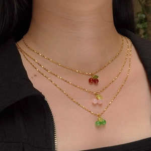 Three-layer gold cherry necklace with red, pink and green gemstone cherry pendants