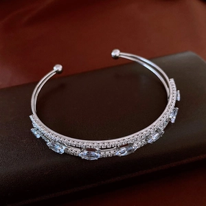 Macro shot of silver-tone open bangle with marquise-cut gems and micro-pave setting