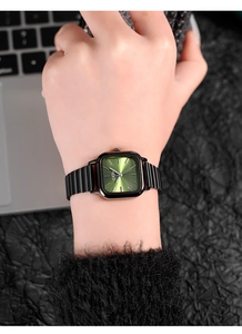 Detail of square green sunray dial watch with black metal link strap on wrist